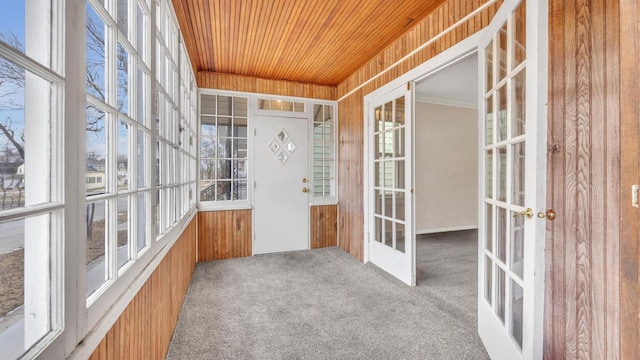 unfurnished sunroom with a wealth of natural light, wooden ceiling, and french doors