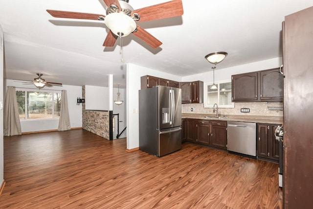 kitchen with dark brown cabinetry, appliances with stainless steel finishes, dark hardwood / wood-style floors, and sink