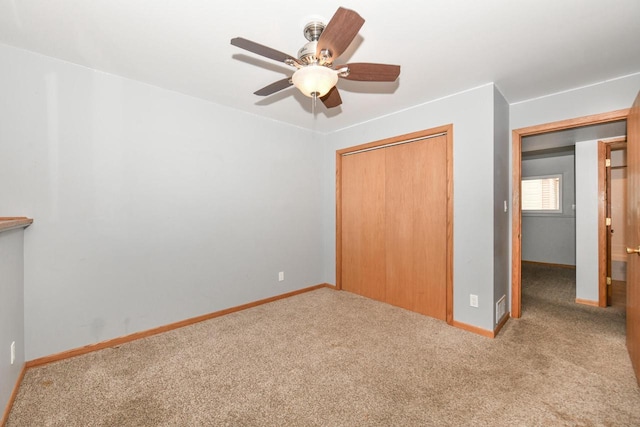 unfurnished bedroom with ceiling fan, a closet, and light carpet