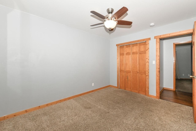 unfurnished bedroom featuring dark colored carpet, ceiling fan, and a closet