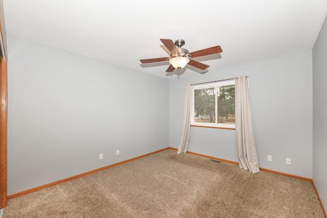 carpeted spare room with ceiling fan