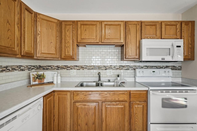 kitchen with white appliances, sink, and tasteful backsplash