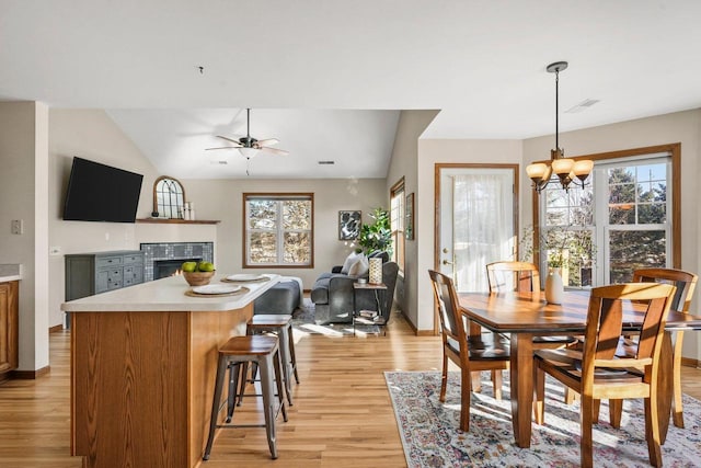 dining area featuring ceiling fan with notable chandelier, light hardwood / wood-style floors, and a wealth of natural light