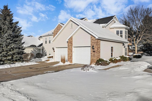 snow covered property featuring a garage