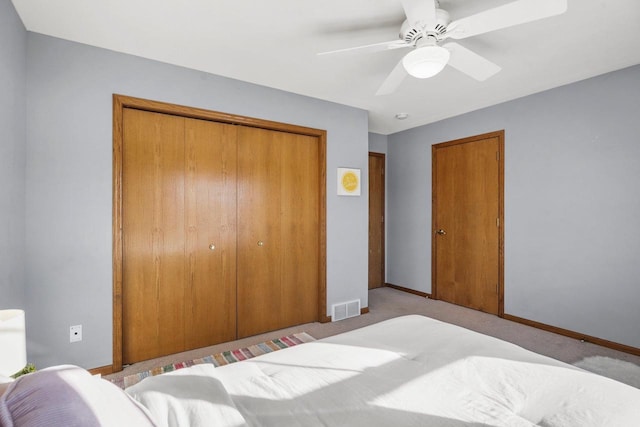 bedroom featuring light carpet, a closet, and ceiling fan