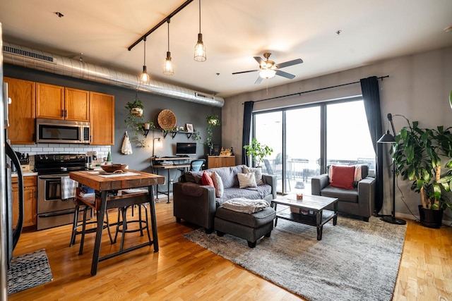 living room featuring ceiling fan and light hardwood / wood-style floors