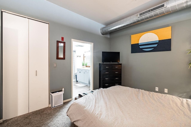 carpeted bedroom featuring ensuite bathroom and a closet