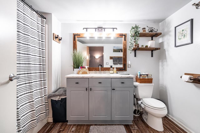 bathroom with a shower with curtain, wood-type flooring, vanity, and toilet