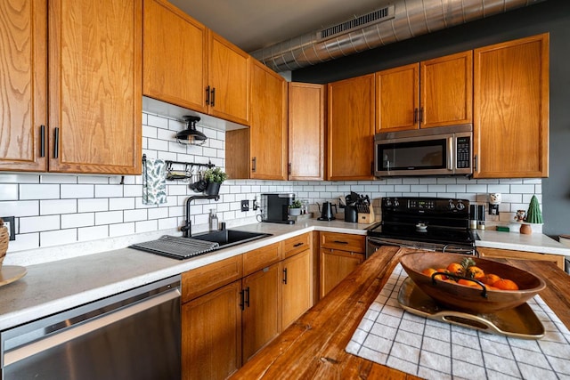 kitchen featuring sink, backsplash, wood-type flooring, and stainless steel appliances