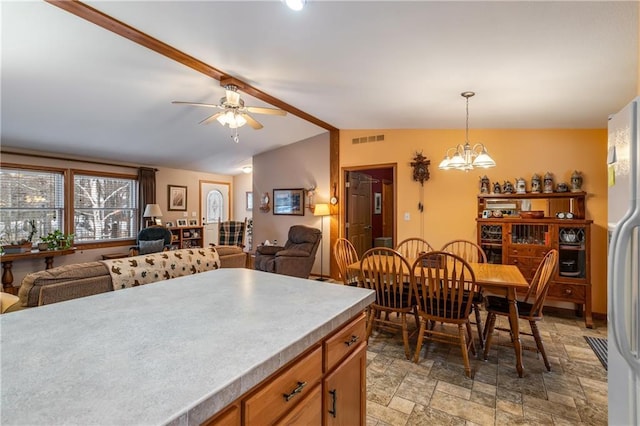 kitchen with lofted ceiling, decorative light fixtures, ceiling fan with notable chandelier, and refrigerator