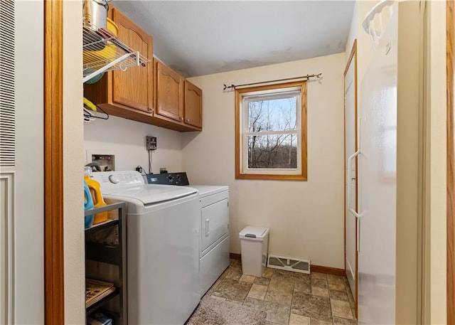 clothes washing area with washing machine and dryer and cabinets