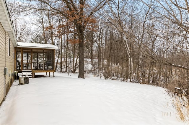 yard layered in snow with a sunroom