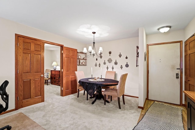 dining room with light colored carpet and a chandelier