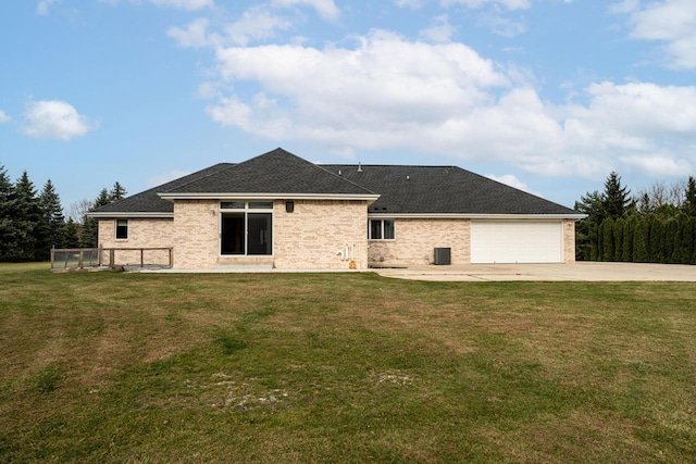 back of house with a garage and a yard