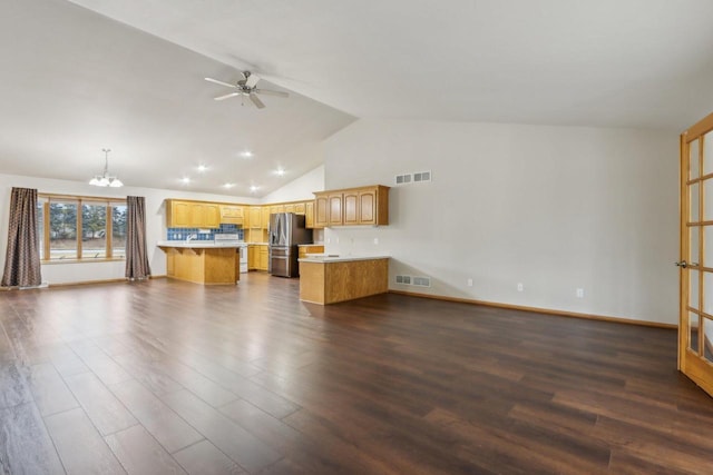 unfurnished living room with ceiling fan with notable chandelier, high vaulted ceiling, and dark hardwood / wood-style floors