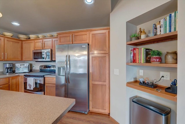 kitchen featuring stainless steel appliances, light brown cabinets, and light hardwood / wood-style flooring