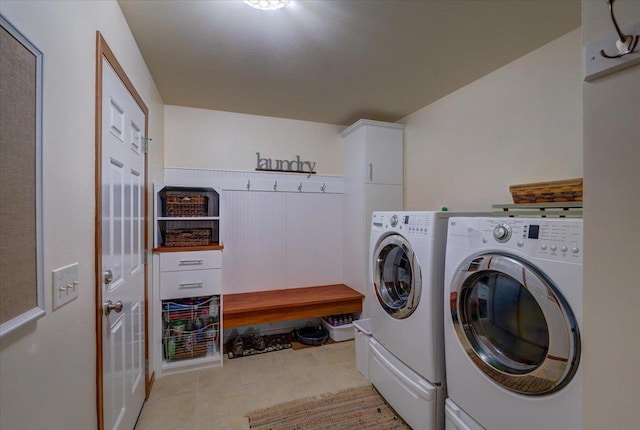 laundry room with cabinets, light tile patterned flooring, and washer and clothes dryer