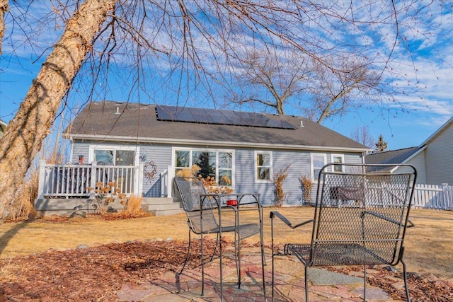 rear view of property with solar panels