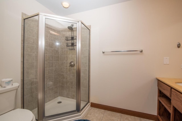 bathroom featuring tile patterned flooring, walk in shower, vanity, and toilet