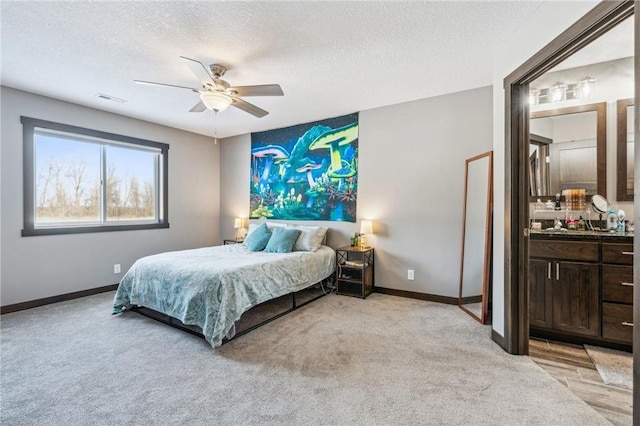 bedroom featuring ceiling fan, light colored carpet, and a textured ceiling