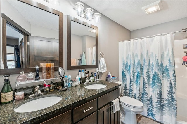 bathroom featuring vanity, curtained shower, a textured ceiling, and toilet