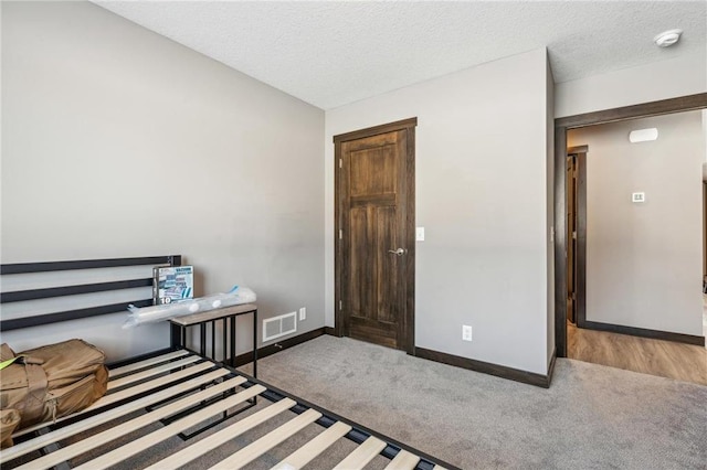 bedroom with carpet floors and a textured ceiling