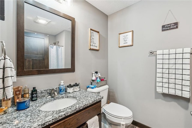 bathroom featuring a shower with curtain, vanity, and toilet