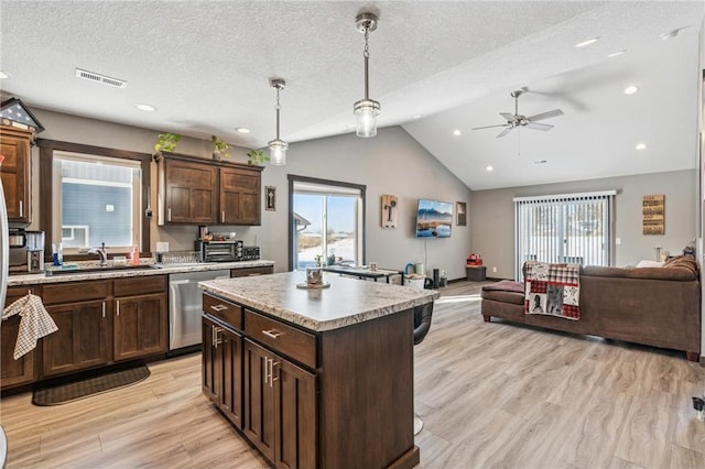 kitchen with sink, hanging light fixtures, a kitchen island, vaulted ceiling, and stainless steel dishwasher