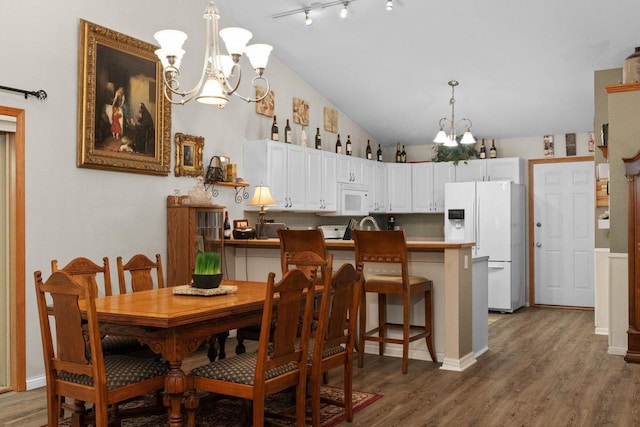 dining room featuring lofted ceiling, a notable chandelier, and dark wood-type flooring