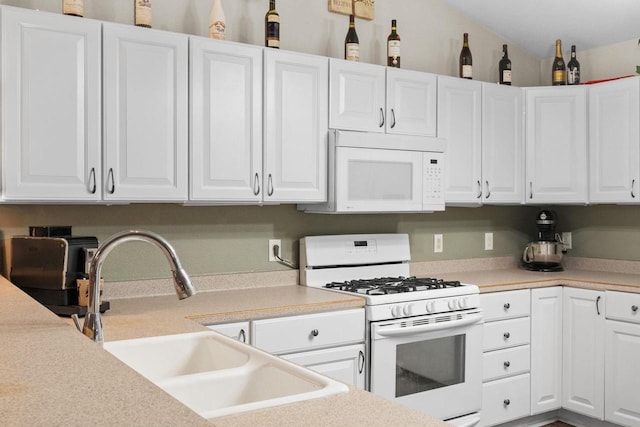 kitchen with white cabinetry, white appliances, lofted ceiling, and sink