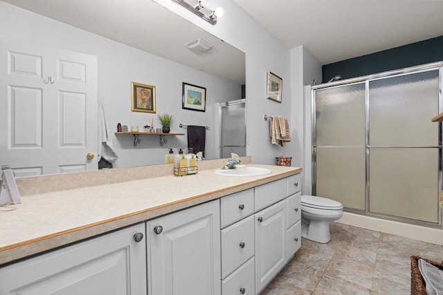 bathroom with vanity, toilet, and a shower with shower door