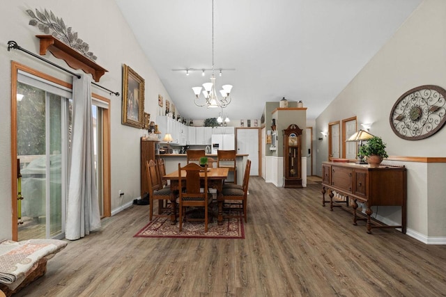 dining room featuring wood-type flooring, high vaulted ceiling, and a chandelier