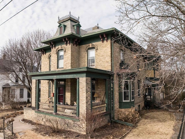 126 E Washington St, Stoughton, WI 53589 - rear view of property featuring covered porch and brick siding