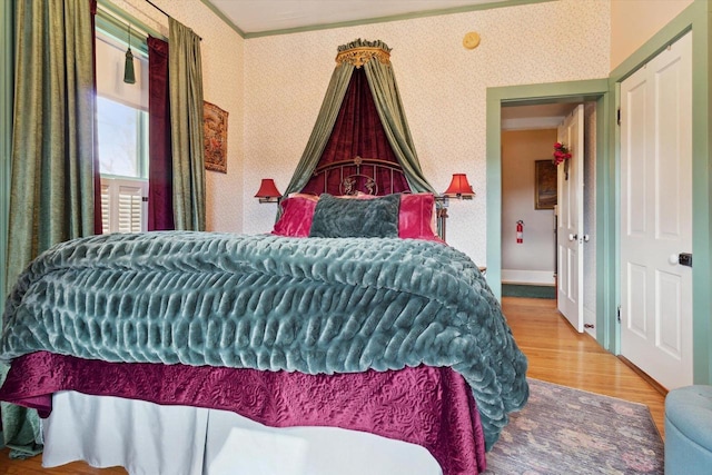 126 E Washington St, Stoughton, WI 53589 - bedroom featuring wallpapered walls, wood finished floors, and ornamental molding