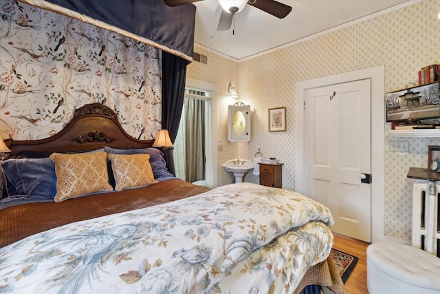 126 E Washington St, Stoughton, WI 53589 - bedroom with wood finished floors, crown molding, wallpapered walls, ceiling fan, and ensuite bath