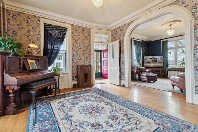 126 E Washington St, Stoughton, WI 53589 - living area with wallpapered walls, wood finished floors, crown molding, and arched walkways