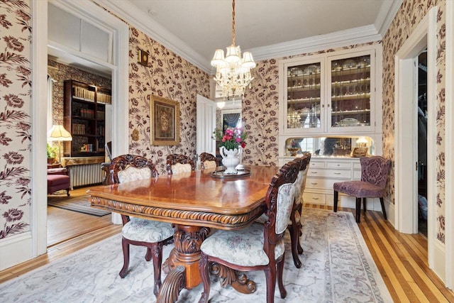 126 E Washington St, Stoughton, WI 53589 - dining space with wallpapered walls, light wood-style flooring, ornamental molding, a chandelier, and radiator