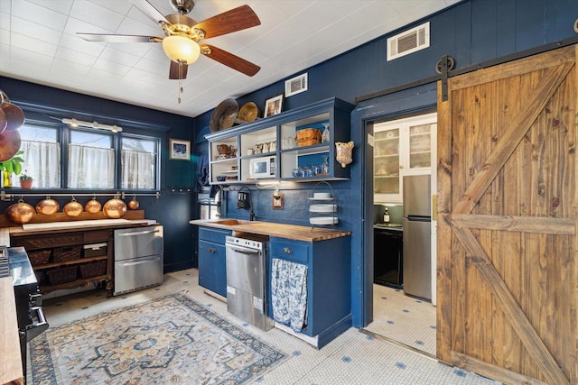 126 E Washington St, Stoughton, WI 53589 - kitchen with blue cabinetry, wood counters, open shelves, a sink, and appliances with stainless steel finishes
