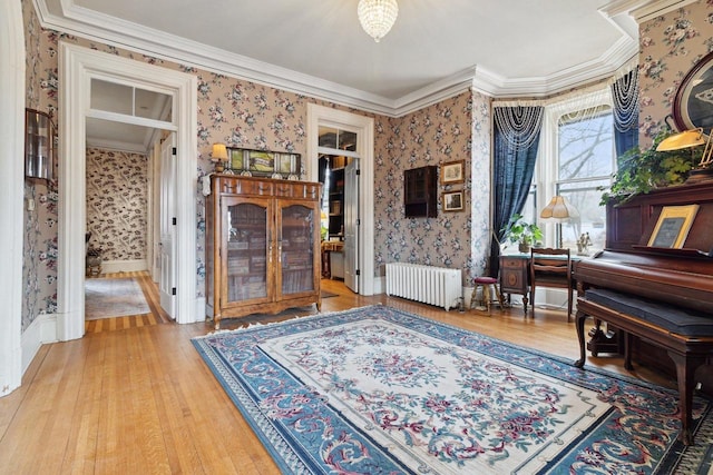 126 E Washington St, Stoughton, WI 53589 - sitting room with wallpapered walls, radiator heating unit, ornamental molding, light wood-type flooring, and baseboards