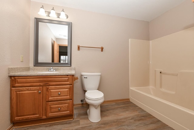 full bathroom featuring vanity, hardwood / wood-style floors, shower / bathtub combination, and toilet