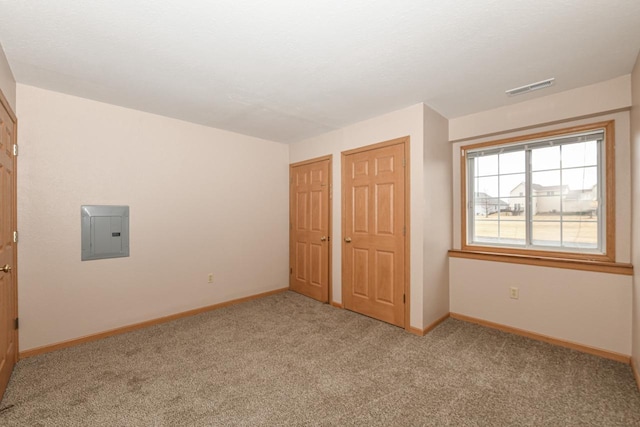 unfurnished bedroom featuring light colored carpet and electric panel