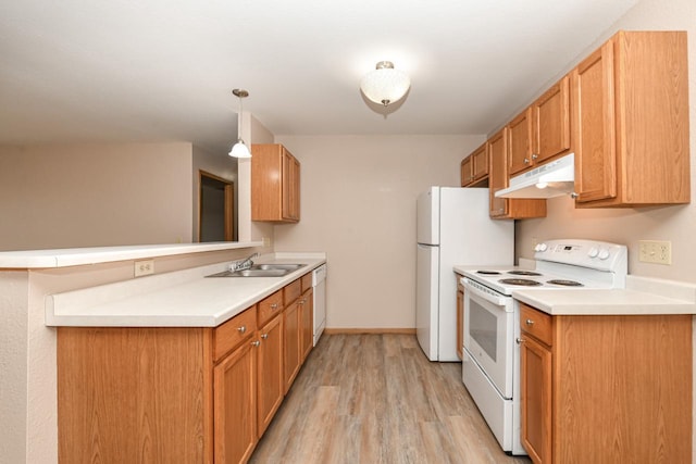 kitchen with sink, kitchen peninsula, pendant lighting, white appliances, and light hardwood / wood-style floors