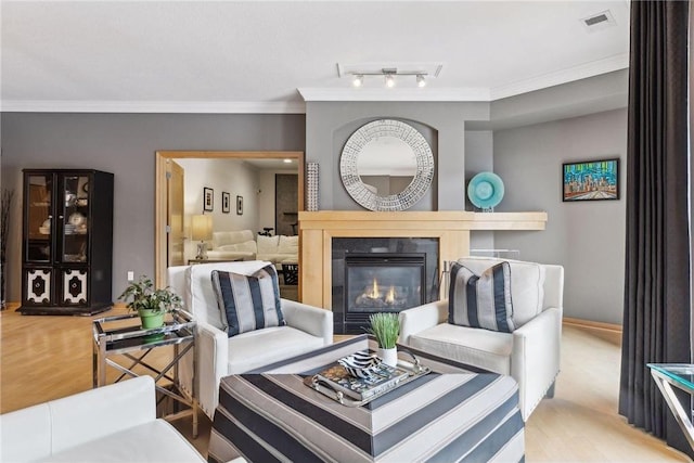 living room featuring crown molding, light hardwood / wood-style floors, and rail lighting