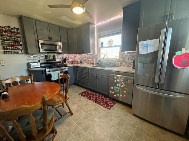 kitchen featuring tasteful backsplash, ceiling fan, stainless steel appliances, and sink