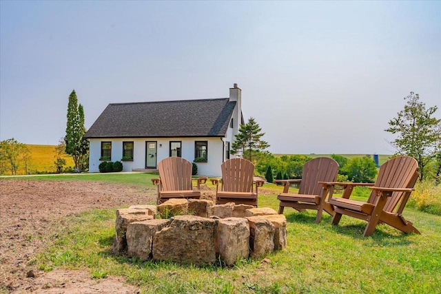 view of front of property with a fire pit and a front lawn