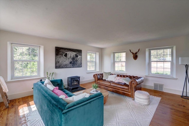 living room with wood-type flooring and a wood stove