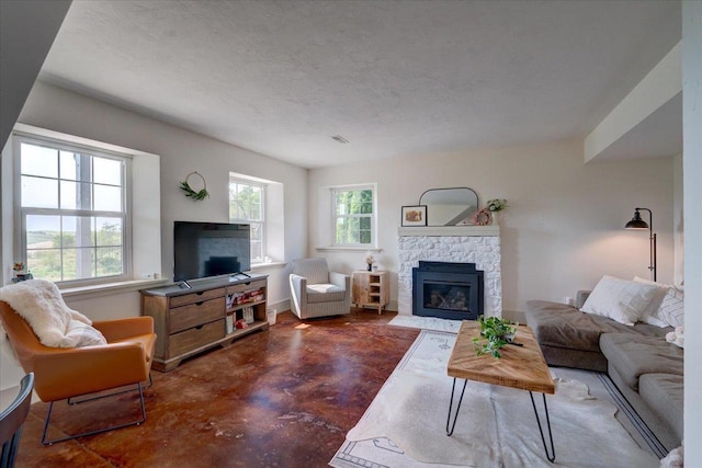 living room featuring a stone fireplace and a textured ceiling