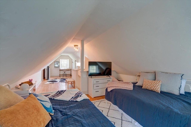 bedroom with vaulted ceiling and light wood-type flooring