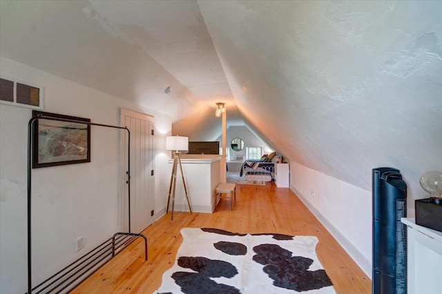 bonus room featuring lofted ceiling and light hardwood / wood-style flooring