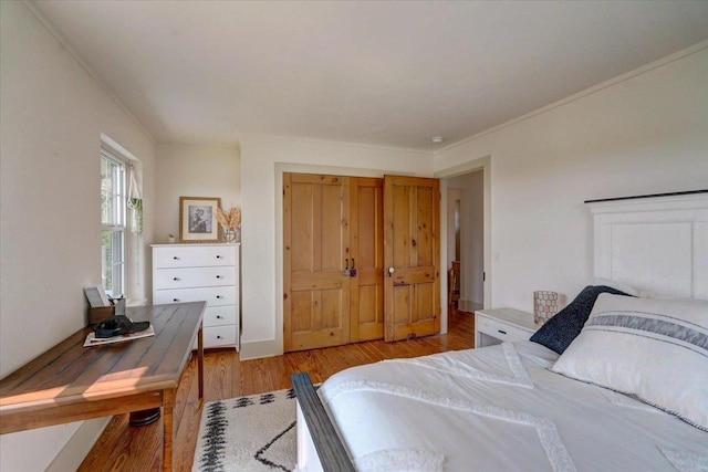 bedroom with crown molding and light hardwood / wood-style flooring